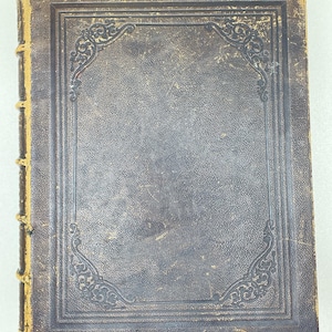 May include: An antique hardback book with a dark brown, textured leather cover featuring embossed decorative borders and corner flourishes. The spine is accented with five raised horizontal bands and shows signs of wear along the edges.