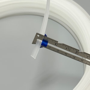 Pu&ograve; includere: Un tubo di plastica bianco, di circa 1,2 cm di diametro, &egrave; avvolto e misurato con un righello. Il tubo &egrave; flessibile e sembra essere fatto di un materiale resistente.