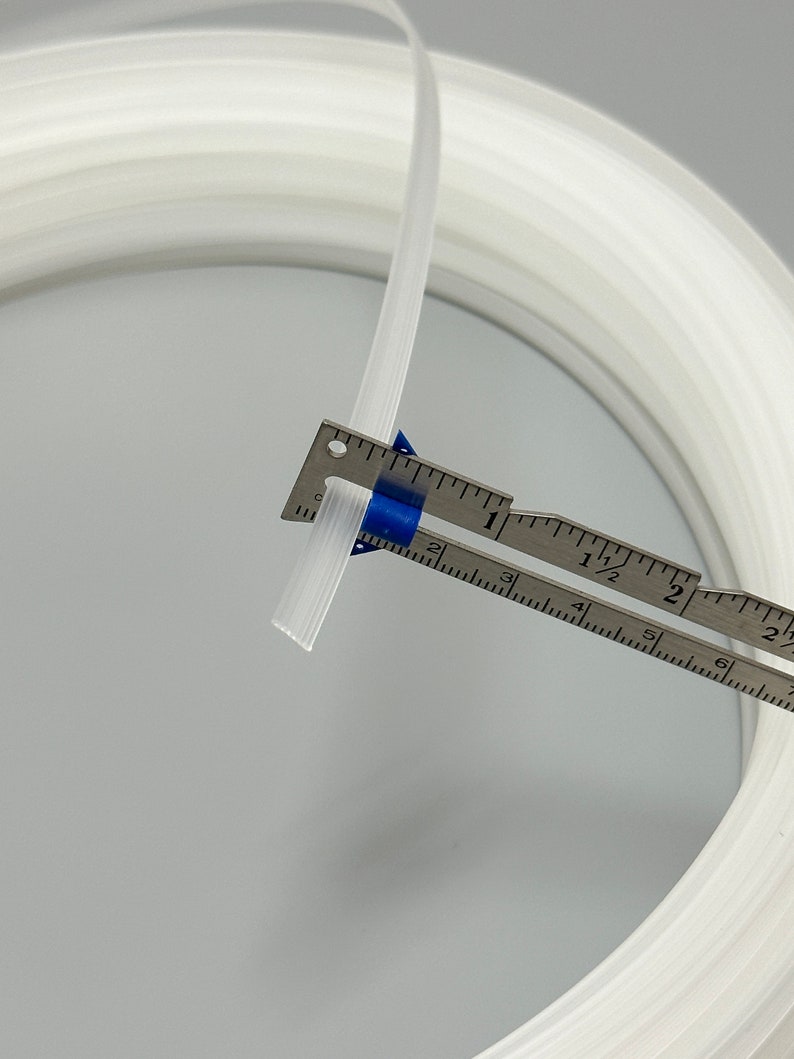 Pu&ograve; includere: Un tubo di plastica bianco, di circa 1,2 cm di diametro, &egrave; avvolto e misurato con un righello. Il tubo &egrave; flessibile e sembra essere fatto di un materiale resistente.