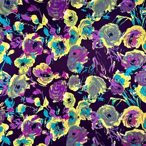 May include: Purple fabric with a floral print featuring yellow, purple, and teal flowers. The background is a deep purple.