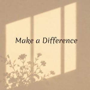 May include: A beige wall featuring the dark brown text Make a Difference centered in the frame. The surface displays a soft shadow cast by a window frame and a floral arrangement, creating a light and dark contrast across the flat plane.