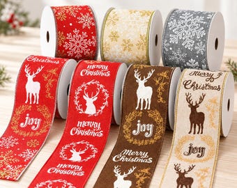 Op de afbeelding: Een collectie van zes rollen decoratief lint met kerstthema's. De linten tonen patronen van witte rendieren, sneeuwvlokken en de teksten Merry Christmas en Joy op rode, bruine, beige en grijze stoffen texturen.