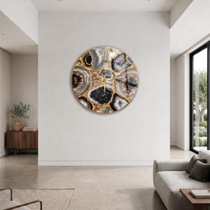 Può includere: Un orologio da parete circolare con un design stampato di fette di agata nere, bianche e grigie con venature color oro. Il quadrante presenta lancette color oro e numeri color oro alle posizioni delle 3, 6, 9 e 12.