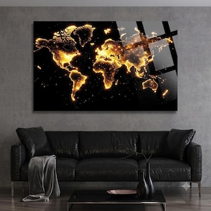 May include: A rectangular wall art piece featuring a world map design with glowing golden light patterns against a solid black background. The continents are illuminated with bright yellow and orange light, creating a high-contrast visual effect.