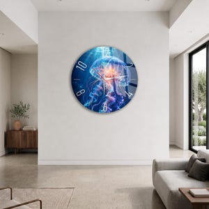 Pode incluir: Um relógio de parede circular com uma cena subaquática vibrante, apresentando uma água-viva brilhante em tons de azul, roxo e laranja. O mostrador exibe números brancos e ponteiros prateados finos, incluindo um ponteiro de segundos vermelho.