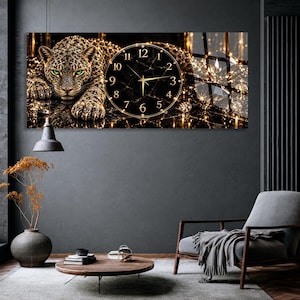 May include: A rectangular wall clock featuring a high-resolution print of a leopard with striking green eyes resting on a dark, reflective surface. The clock face is circular with a black marble pattern, gold numerals, and gold hands.