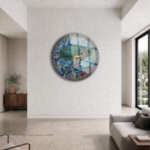 May include: A circular wall clock featuring a vibrant mosaic-style illustration of a sea turtle swimming among blue waves, coral, and aquatic plants. The clock face has gold-colored hands and gold-colored numerals set against a dark border.
