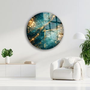 May include: A circular wall clock featuring a deep teal and blue marble-like background with shimmering gold veins and bokeh light effects. The clock face displays gold-coloured numerals at the 12, 9, and 6 positions with thin gold hands.