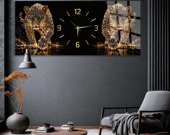 May include: A rectangular wall clock featuring a black background with two golden, glowing leopards walking toward the viewer. The clock face has gold-colored numbers at the 3, 6, 9, and 12 positions, with thin gold hands indicating the current time.