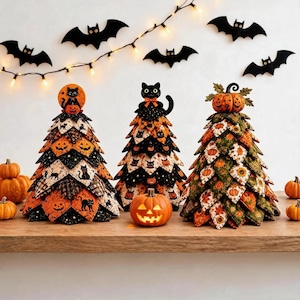Könnte beinhalten: Drei dekorative Stoffbäume mit Halloween-Motiven. Der linke Baum zeigt orangefarbene und schwarze Katzen- und Kürbismuster. Der mittlere Baum ist mit schwarzen Katzen verziert. Der rechte Baum zeigt grüne und orangefarbene Kürbisdrucke.