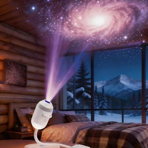 Könnte beinhalten: Ein weißer, zylindrischer Galaxie-Projektor mit flexiblem Hals und Ein-Aus-Schalter, der einen violetten Lichtstrahl aussendet, welcher ein wirbelndes Nebel- und Sternenmuster an die Decke eines Zimmers mit Blick auf eine verschneite Berglandschaft wirft.