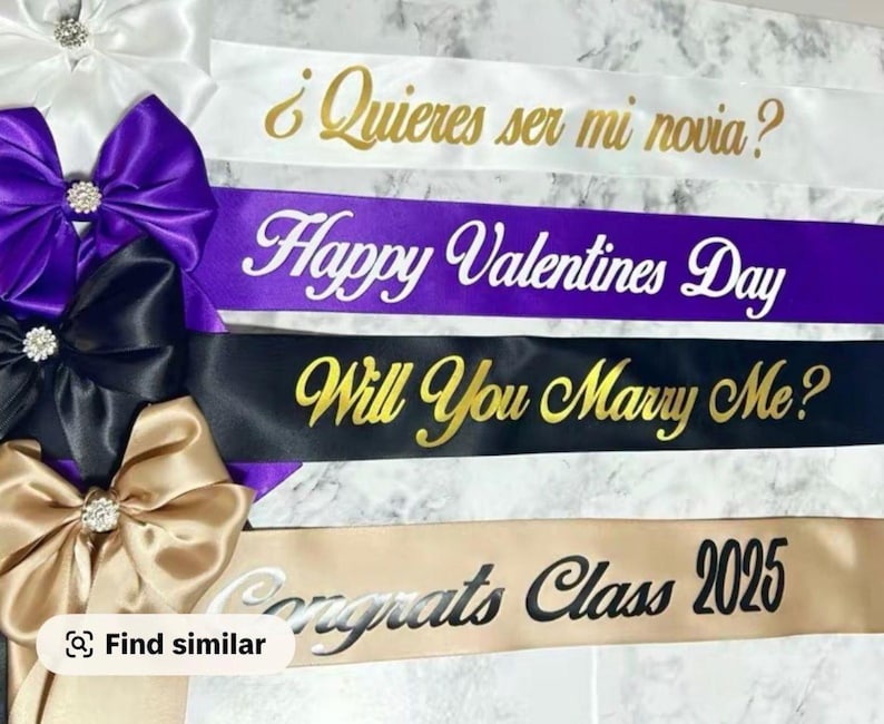 May include: Satin sashes in white, purple, black, and gold, with text in gold and white. The sashes have text that reads "&iquest;Quieres ser mi novia?", "Happy Valentines Day", "Will You Marry Me?", and "Congrats Class 2025". Each sash is adorned with a bow.