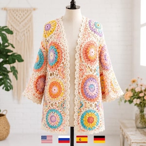 May include: A cream-colored, open-front crochet cardigan with colorful circular patterns. The cardigan features a scalloped edge and three-quarter length sleeves. The circular patterns include shades of orange, yellow, blue, and purple.