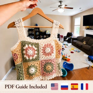 May include: A handmade crochet top in a patchwork design, featuring squares of cream, green, pink, and yellow. The top is held on a wooden hanger. The text "PDF Guide Included" is visible at the bottom of the image.