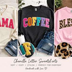Op de afbeelding: Drie sweaters met ronde hals en chenille varsity-letters. De crèmekleurige sweater toont het woord MAMA in roze, de zwarte sweater toont COFFEE in regenboogkleuren en de roze sweater toont BLESSED in een luipaardprintpatroon.