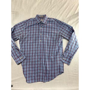 May include: A long-sleeve button-down shirt featuring a light blue base with a dark red and white plaid grid pattern. The shirt includes a standard collar, a front button placket with light-colored buttons, and buttoned cuffs on each sleeve.
