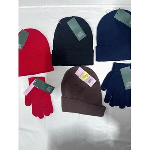 May include: Assortment of beanies and gloves in red, black, brown, and navy blue. Each beanie has a folded brim. The gloves are a matching color to the beanies. All items have a tag attached.