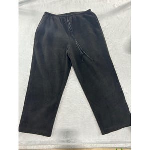 May include: Solid black fleece sweatpants featuring a comfortable elastic waistband with an integrated matching black drawstring cord. These trousers have a relaxed, straight-leg fit and a soft, textured fabric finish throughout the entire garment.