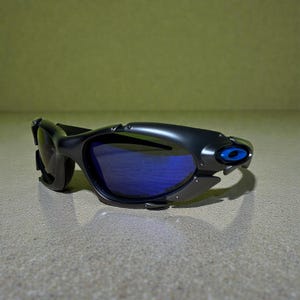 May include: Black sunglasses with blue lenses. The sunglasses have a sleek, modern design with a curved frame and a small blue accent on the side. The lenses are a vibrant blue color.