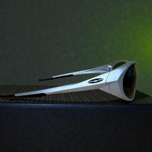 Op de afbeelding: Zilverkleurige en zwarte sportzonnebril met een strak, modern design. De zonnebril heeft een wrap-around stijl met donkere glazen en een zilverkleurig montuur. Het Oakley-logo is zichtbaar aan de zijkant. De zonnebril ligt op een getextureerd oppervlak.