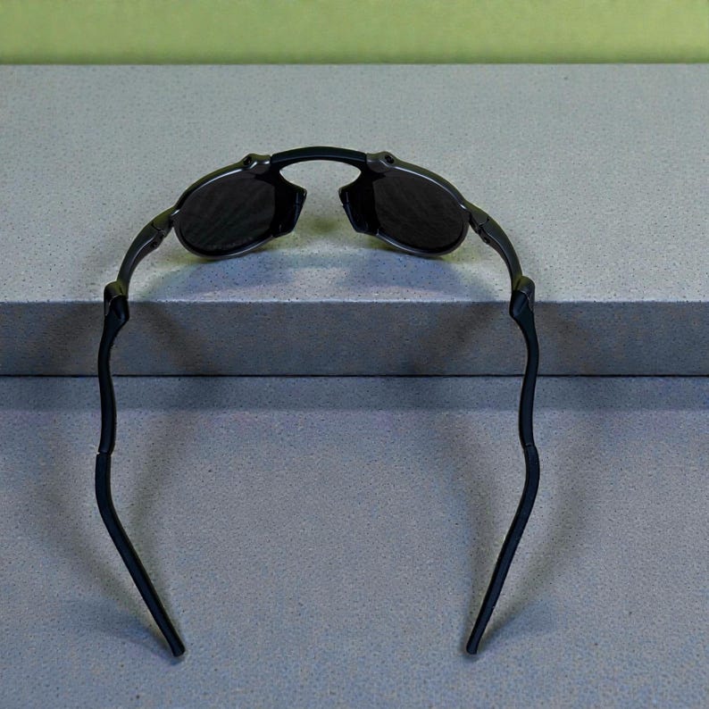 May include: Black sunglasses with a curved frame and dark lenses. The sunglasses have a sleek, modern design, suitable for outdoor activities. The arms of the sunglasses are thin and extend outward.