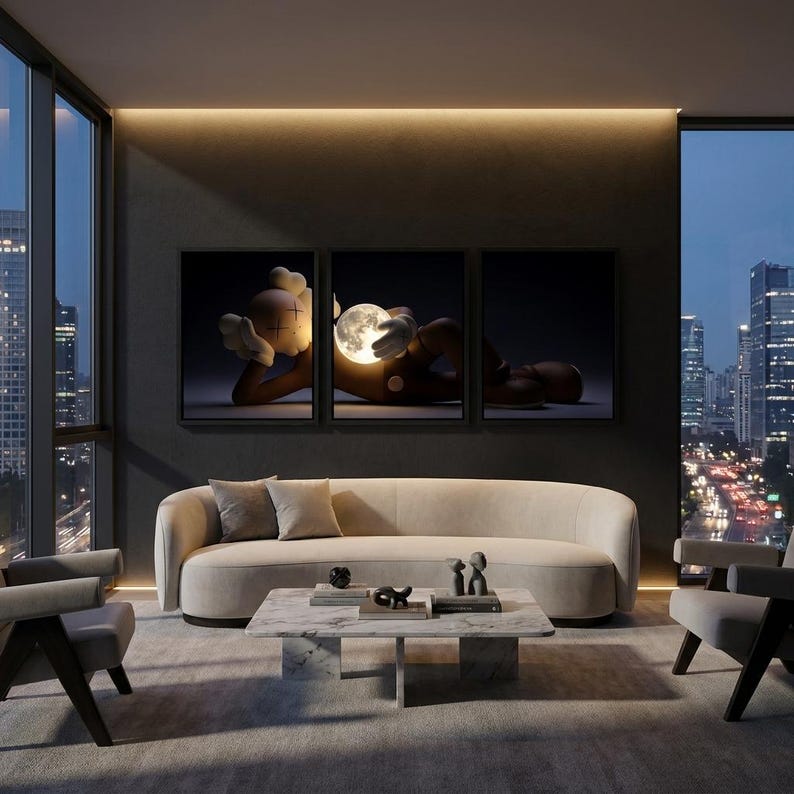 May include: A triptych wall art set featuring a brown cartoon character with X-shaped eyes lying down and holding a glowing, illuminated moon sphere. The artwork is displayed above a curved beige sofa, a marble coffee table, and two armchairs.