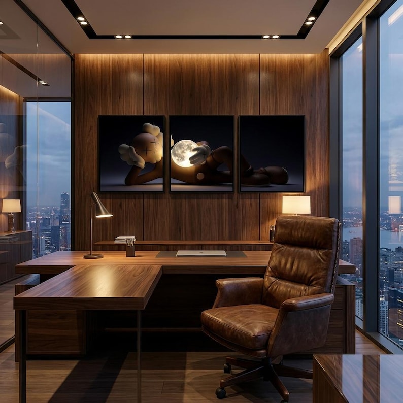 May include: A triptych wall art set featuring a stylized character with crossed-out eyes lying down and holding a glowing, illuminated moon. The artwork is displayed on a dark wood paneled wall above a wooden executive desk and a brown leather chair.