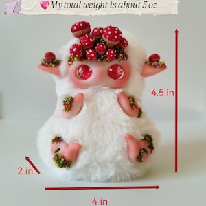 May include: A white plush creature with large red eyes, adorned with red mushroom caps and floral accents. It features weighted beads at the bottom, a total weight of 5 oz, and measures 4.5 inches in height, 4 inches in width, and 2 inches in depth.