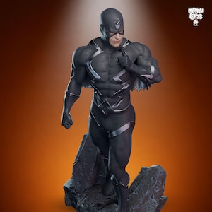 Puede incluir: Estatua detallada de un superh&eacute;roe con un traje negro con detalles plateados, de pie sobre una base rocosa. La figura tiene una m&aacute;scara y se lleva un dedo a los labios. El fondo es un degradado de naranja y marr&oacute;n.