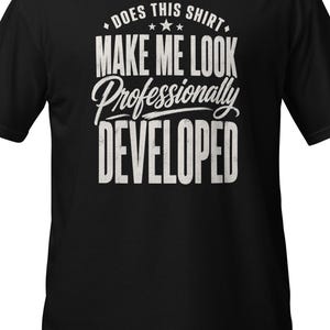 Puede incluir: Una camiseta negra de manga corta con texto blanco de estilo desgastado en el pecho que dice: DOES THIS SHIRT MAKE ME LOOK Professionally DEVELOPED, acentuado con tres pequeñas estrellas sobre la palabra Professionally.