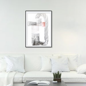 Puede incluir: Un dibujo abstracto en blanco y negro en un marco negro colgado en una pared blanca sobre un sofá blanco con almohadas blancas.