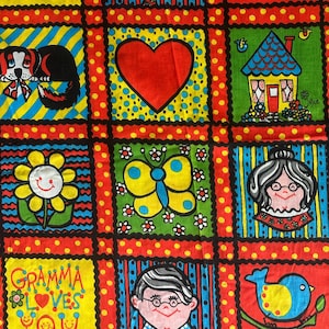 May include: A colorful fabric with a repeating pattern of cartoon illustrations. The design includes a dog, a heart, a house, a flower, a butterfly, and faces. The words "Gramma Loves You" and "Loves You" are also featured.