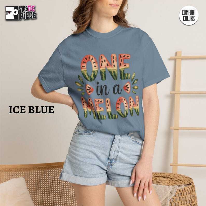 Ice Blue Comfort Colors 1717 t-shirt with watercolor watermelon graphic, styled with denim shorts on female model