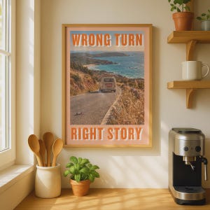 May include: A rectangular wall art print in a light wood frame featuring a coastal landscape with a van on a road. The text WRONG TURN is printed in orange at the top and RIGHT STORY is printed in orange at the bottom of the image.