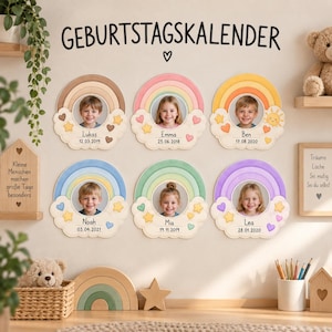 May include: A wall display titled GEBURTSTAGSKALENDER featuring six circular rainbow-themed photo frames. Each frame displays a child's portrait, name, and birth date, decorated with clouds, stars, and hearts in various pastel colors.