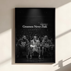 May include: A black and white framed wall art print featuring three basketball players sitting on a bench in an arena. The text "Greatness Never Ends." is printed in white in the center. The image captures a professional sports scene.