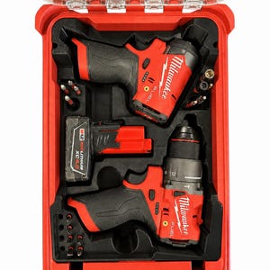 Peut inclure: Un kit d'outils électriques Milwaukee Fuel rouge dans une mallette de transport en plastique rigide. L'ensemble comprend deux outils sans fil, une batterie M12 Redlithium XC4.0 rouge et plusieurs forets en métal dans des inserts en mousse noire.