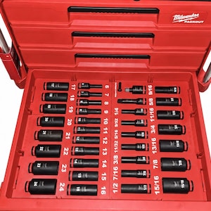 May include: A red Milwaukee Packout tool storage unit with an open drawer containing a black socket set. The interior tray features labeled slots for metric sockets numbered 6 through 24 and imperial sockets ranging from 1/4 to 15/16 inches.
