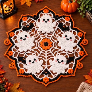 May include: A round, crocheted Halloween doily featuring a white spiderweb pattern, four white ghosts with pink cheeks, black bats, and small orange pumpkins. The border is accented with orange flowers and black trim, creating a festive design.