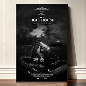 May include: A black and white movie poster for The Lighthouse featuring two figures on a rocky shore at night. One figure stands while the other kneels, both emitting beams of light from their eyes. The title and cast credits are printed in white.