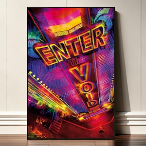 May include: A framed movie poster for Enter the Void, a Gaspar Noé film. The artwork features vibrant neon typography in yellow, orange, and red against a dark, abstract background with glowing blue and purple light streaks and geometric patterns.