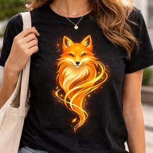 Woman wearing a black Golden Fox graphic tee with a large orange and gold fox artwork centered on the chest.