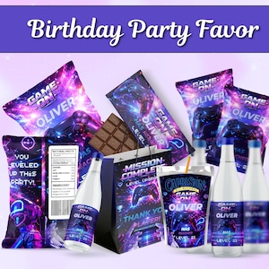 Pode incluir: Um conjunto de lembranças de festa de aniversário com um design de videojogos de galáxia e o texto "GAME ON OLIVER" e "MISSION COMPLETE". O conjunto inclui sacos de snacks, uma barra de chocolate, um saco de presente, sumos e garrafas.