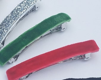 May include: Four hair clips with silver metal clasps. One clip is silver glitter, one is green velvet, one is red velvet, and one is black velvet.