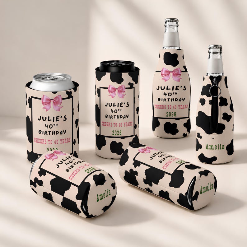 May include: A collection of beverage insulators featuring a black and white cow print pattern. Some insulators display a pink bow and text reading JULIE'S 40TH BIRTHDAY CHEERS TO 40 YEARS 2026, while others are personalized with the name AMELIA.