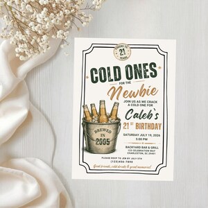 May include: A rectangular birthday invitation card featuring a metal bucket filled with beer bottles. The text reads COLD ONES FOR THE Newbie JOIN US AS WE CRACK A COLD ONE FOR Caleb's 21ST BIRTHDAY, BREWED IN 2005, and event details.