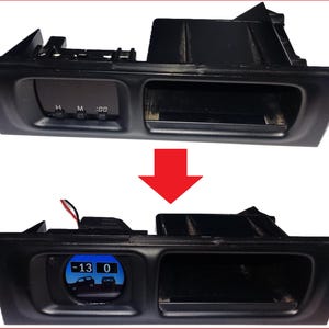 May include: Black car dashboard component with a digital display showing a temperature of -13 degrees Celsius. The component has a rectangular shape with a recessed area and a digital clock display. The image shows the component before and after modification.