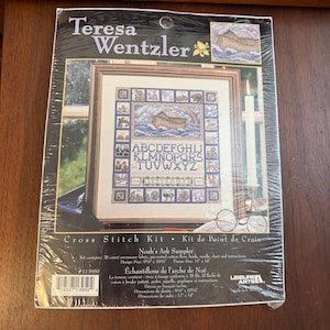 May include: A cross-stitch kit featuring a framed sampler design of Noah's Ark. The kit includes fabric, floss, a needle, chart, and instructions. The design size is 9.75 x 10.5 inches, and the frame size is 11 x 14 inches.
