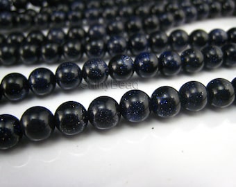 May include: A strand of dark blue gemstone beads with a speckled, glittery finish. The beads are round and uniform in size.