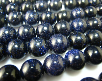 May include: A strand of dark blue gemstone beads with a sparkly, speckled finish.